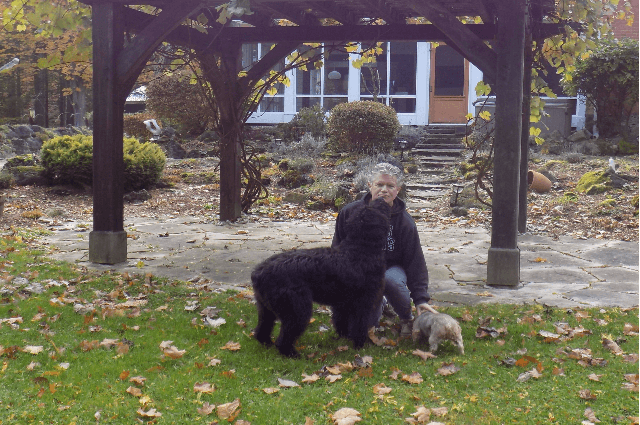 man, two dogs, house, trees, outside